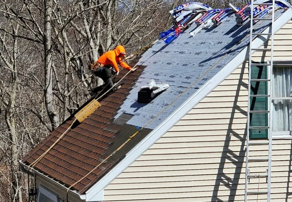 Roofer installing an architectural asphalt shingle roof that probably costs about 7 dollars per square foot.