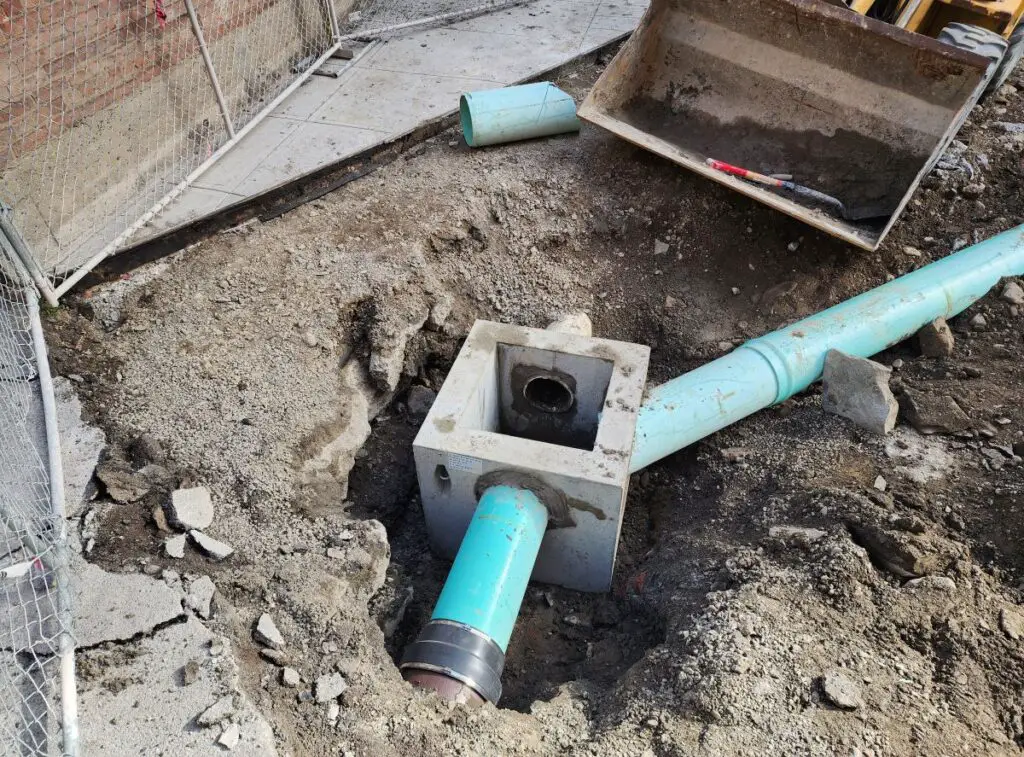 Installing a catch basin outside of a commercial building.