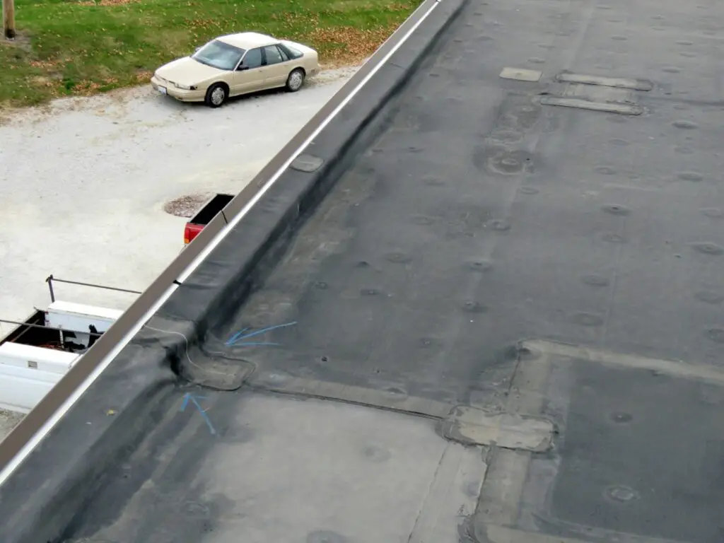 A hole in the perimeter flashing on an EPDM roof. Do NOT try to repair an EPDM roof with roof cement.