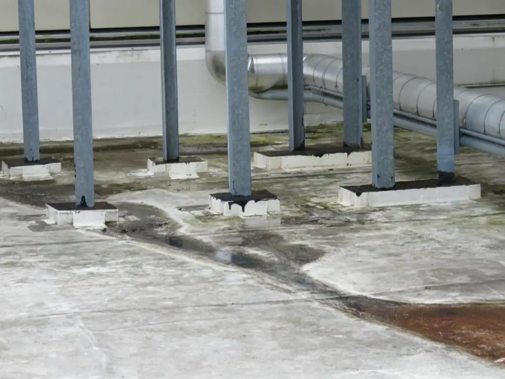 Large, box-shaped pitch pans at irregularly-shaped equipment supports on a PVC roof.