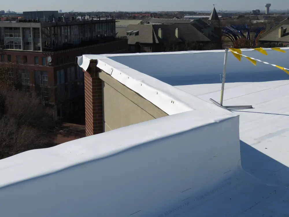 A TPO single-ply roof membrane at the parapet wall during a roof installation.