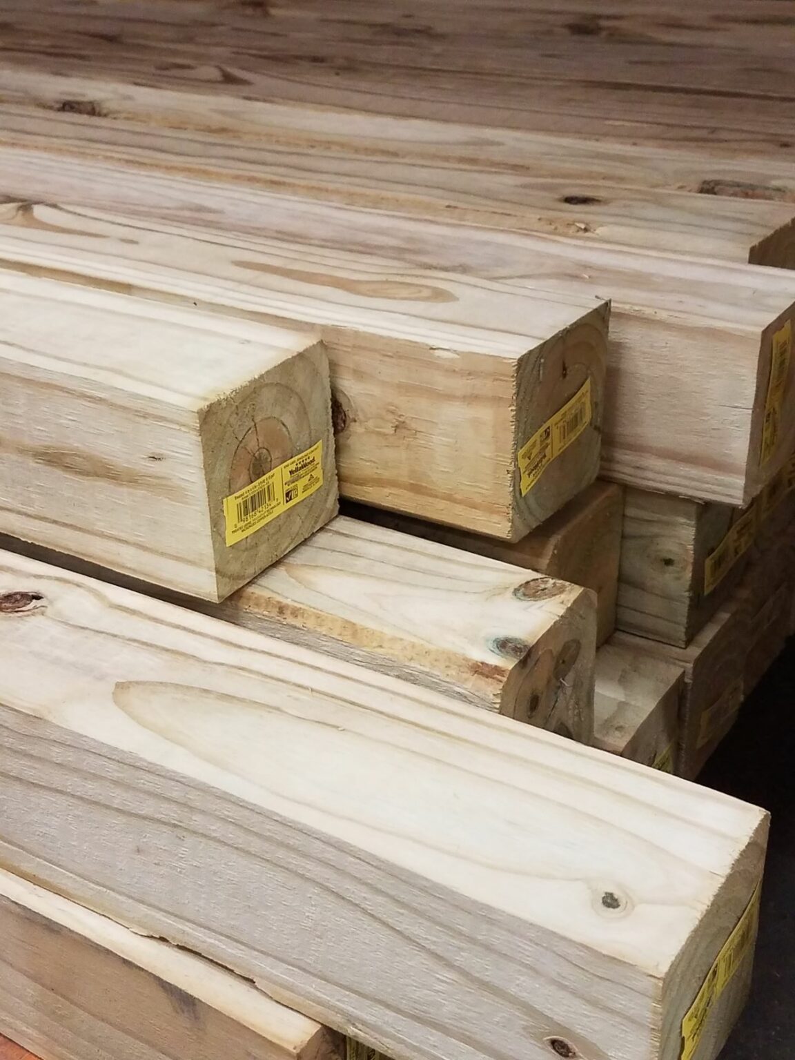 A stack of pressure-treated 4×4 lumber. These posts weigh around 3 and a half pounds per foot.