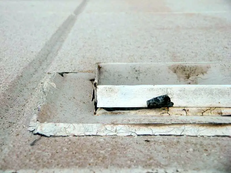 Deteriorated building sealant around the outside of a roof scupper.