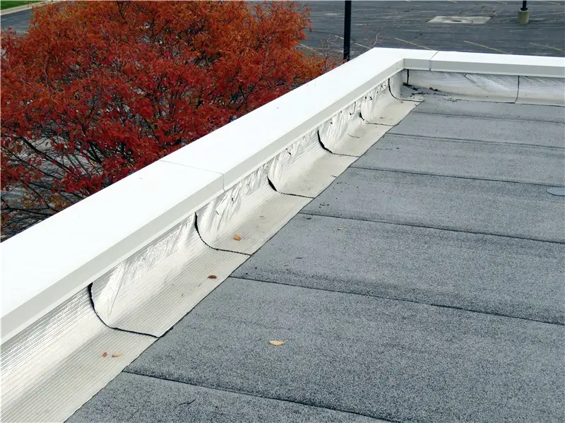 Foil-surfaced modified bitumen roof flashings on a low-slope commercial roof.