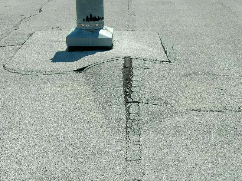 A large roof blister near a vent penetration on a modified bitumen roof.