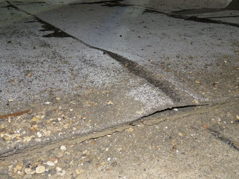 The cross-section of a large blister in a modified bitumen roof where the top layer of roofing has been cut and partially removed.