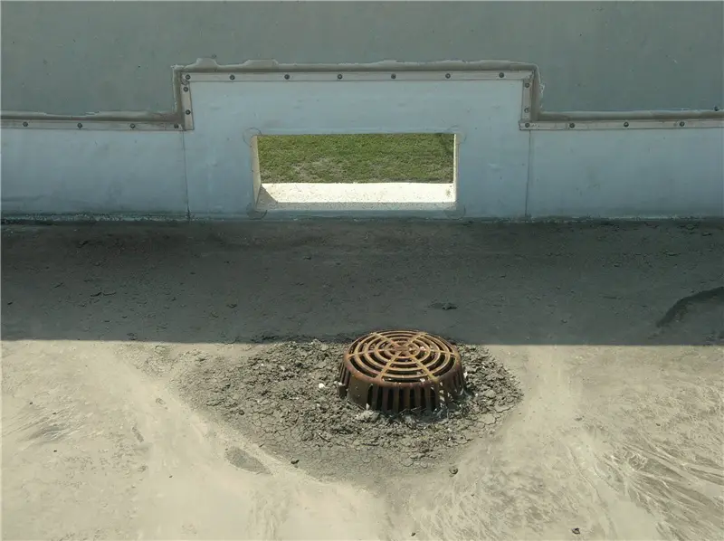 A thru-wall overflow scupper near a roof drain on a (really dirty) TPO roof.