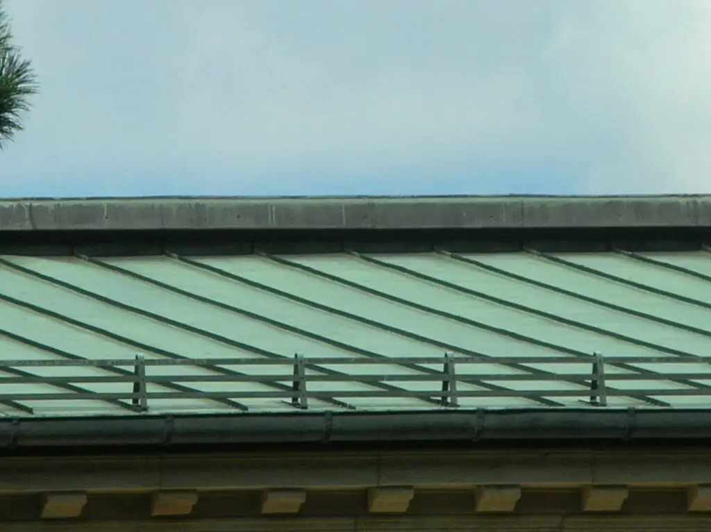 A section of standing seam copper roof viewed from the ground.