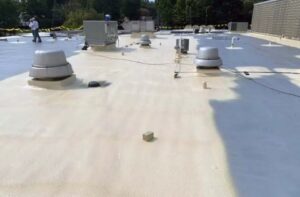 A spray polyurethane foam roof while the silicone coating is being applied.