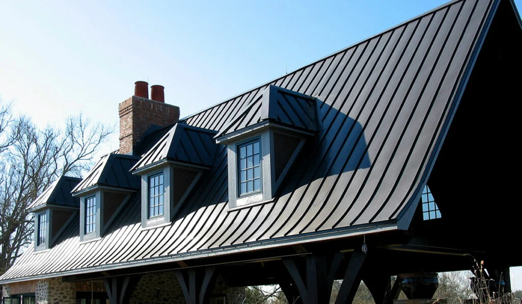 A dark-brown residential standing seam metal roof with dormers.