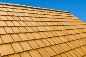 A cedar shingle roof against a bright blue sky.