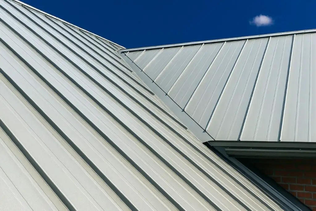 A silver-colored standing seam metal roof with two roof planes and a roof valley between them.