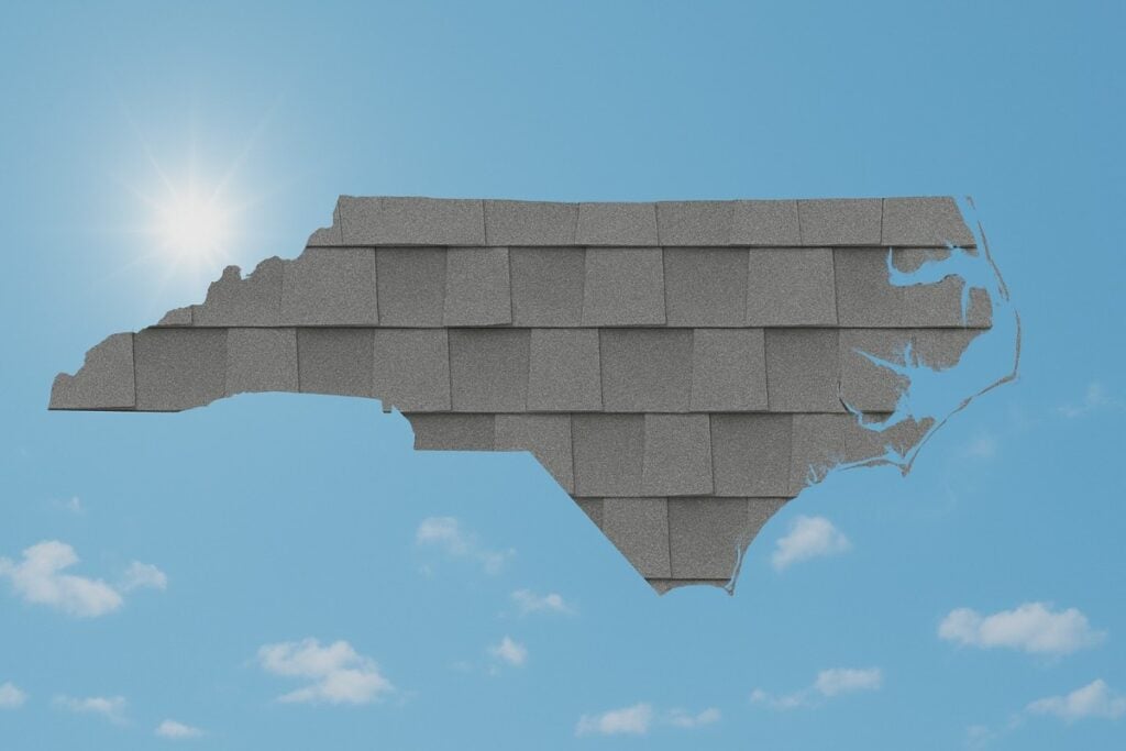 Outline of the State of North Carolina filled in with an image of asphalt shingles, set against a background of blue sky with clouds and sun.