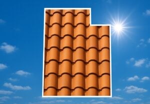 Outline of the State of Utah filled in with an image of clay roof tiles, set against a background of blue sky with clouds and sun.