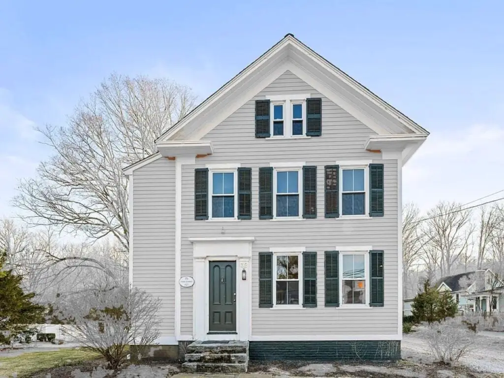 A light gray house with a prominent box gable.