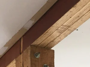 Three LVL beams on top of a support column used for structural support in a house.