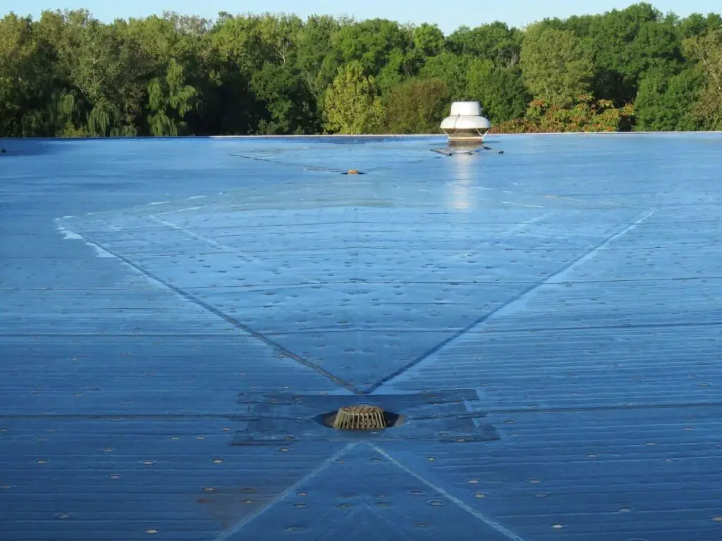 Fully-adhered EPDM roofing with roof crickets and drains.