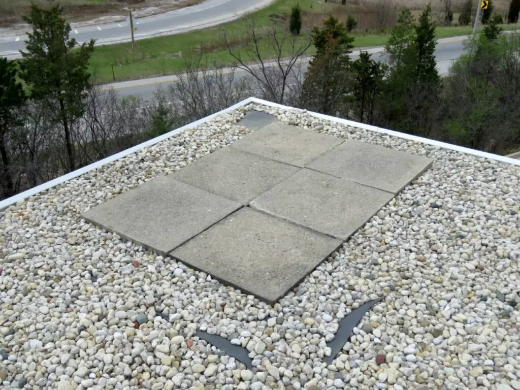 Ballast stone and concrete pavers at the corner of a ballasted EPDM roof.